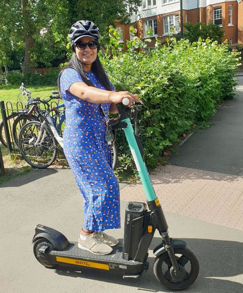 Woman in blue dress on e-scooter