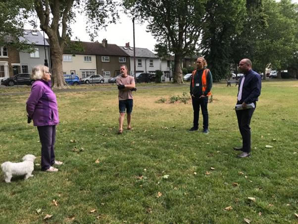 A group of people standing on top of a grass covered field  Description automatically generated