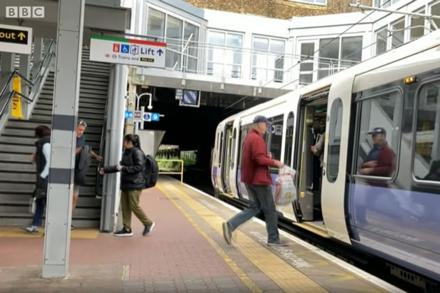 Passenger boarding an Elizabeth Line train at Ealing Broadway station