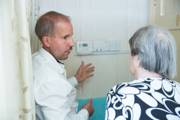 A carer is shown how to use the new heating system by an advisor