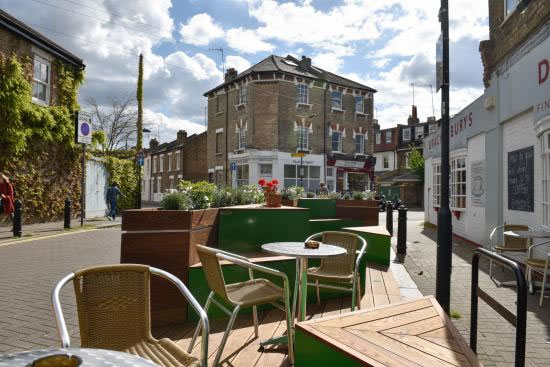 Tables, chairs and planters on a pedestrianised street in Hammersmith