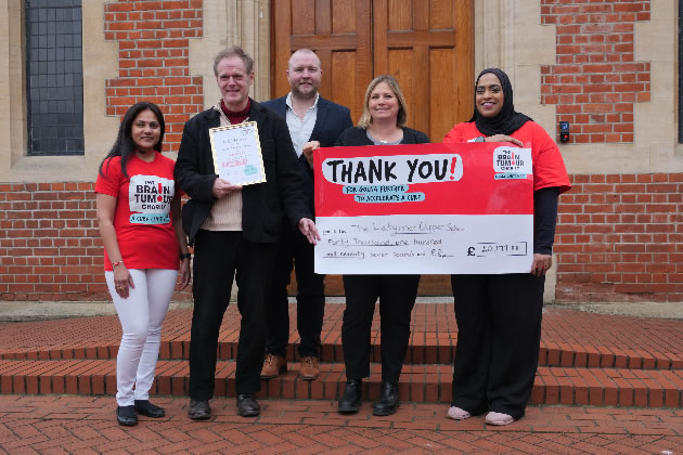 A cheque from Laytmer School is presented to The Brain Tumour Charity